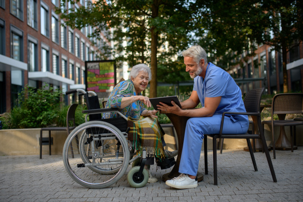 Doctor explaining medication to senior patient and answering her questions about diagnosis.