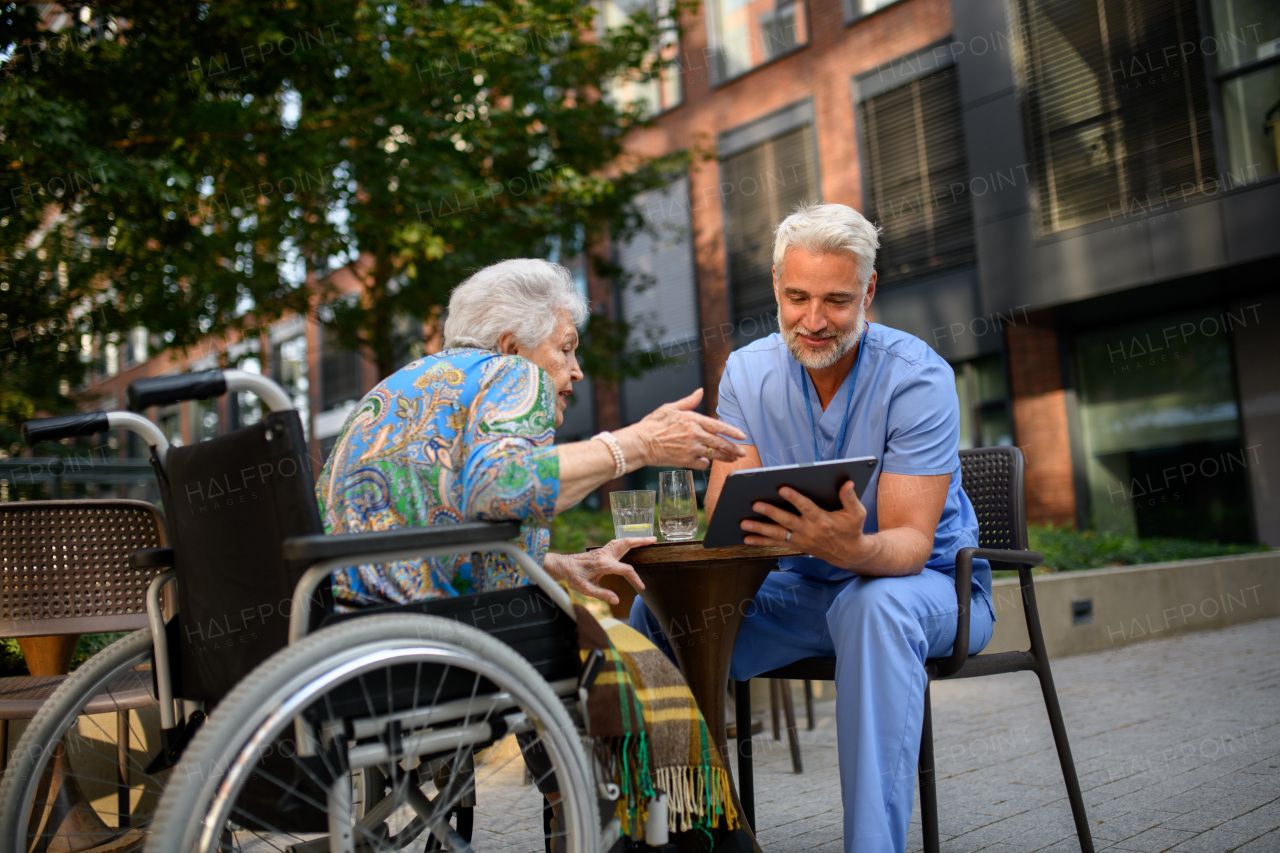 Doctor explaining medication to senior patient and answering her questions about diagnosis.