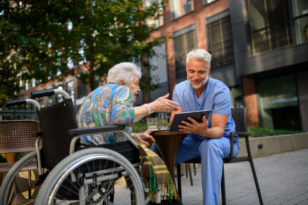 Doctor explaining medication to senior patient and answering her questions about diagnosis.
