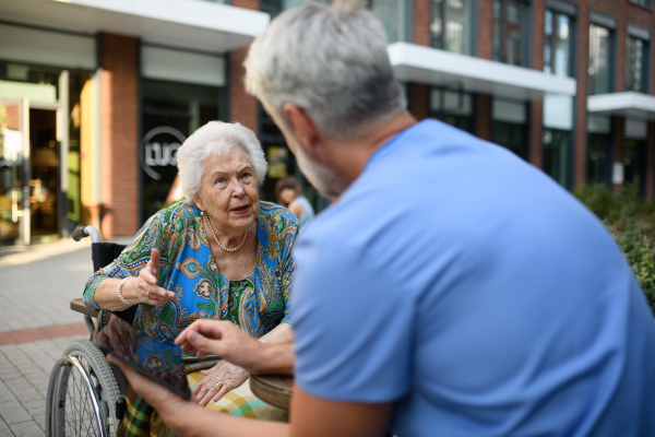Doctor explaining medication to senior patient and answering her questions about diagnosis.