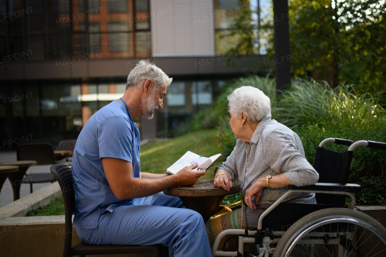 Doctor explaining medication to senior patient and answering her questions about diagnosis.