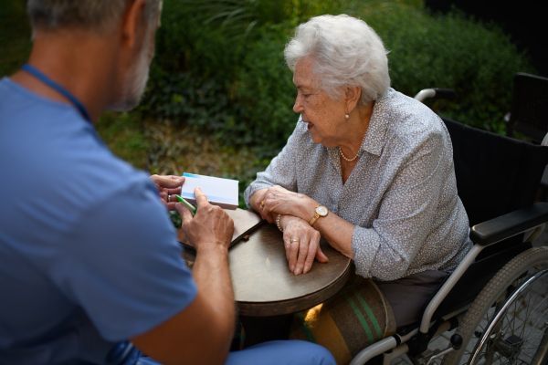 Doctor explaining medication to senior patient and answering her questions about diagnosis.