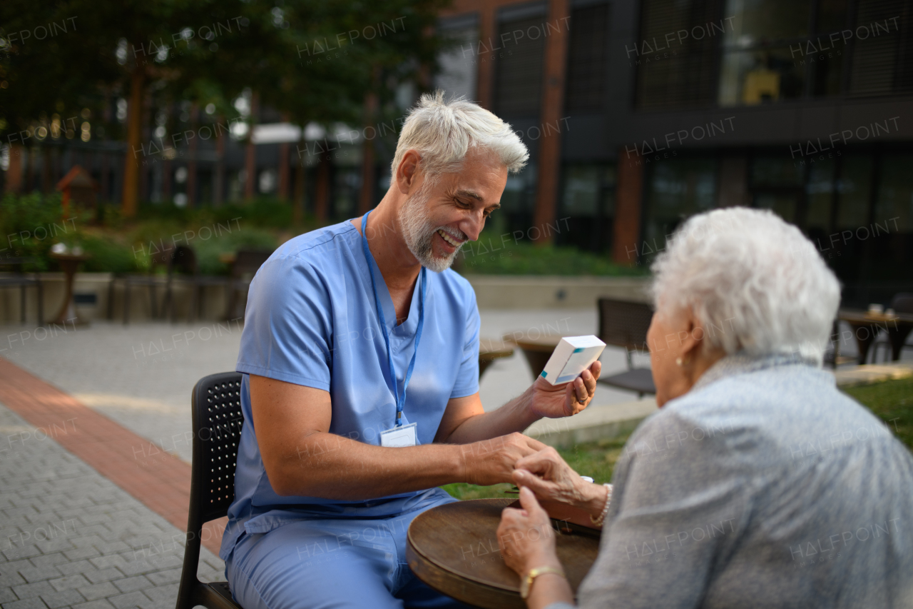 Doctor explaining medication to senior patient and answering her questions about diagnosis.