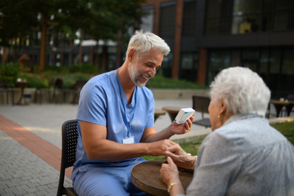 Doctor explaining medication to senior patient and answering her questions about diagnosis.