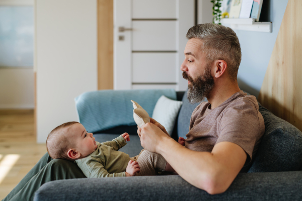 Father holding a baby boy on his lap.