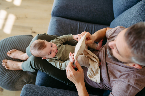 Top view of father holding a baby boy on his lap.
