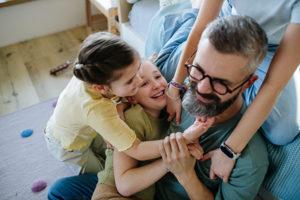 Portrait of father with three daughters at home. Girl dad concept.