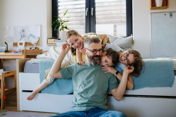 Portrait of father with three daughters at home. Girl dad concept.