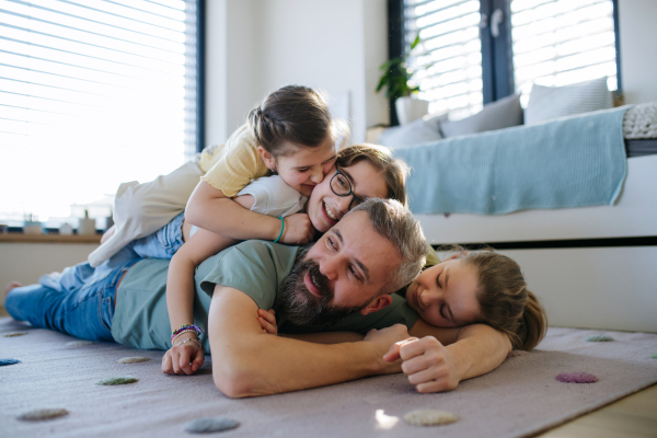 Portrait of father with three daughters at home. Girl dad concept.