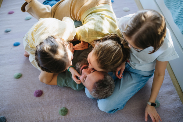 Portrait of father with three daughters at home. Girl dad concept.