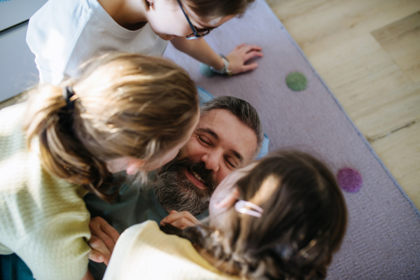 Portrait of father with three daughters at home. Girl dad concept.
