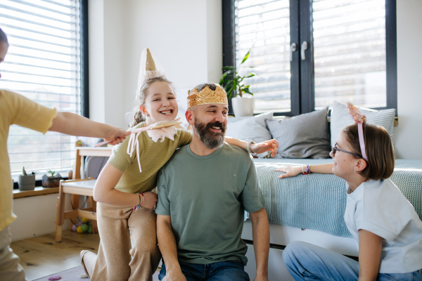 Portrait of father with three daughters at home. Girl dad concept.