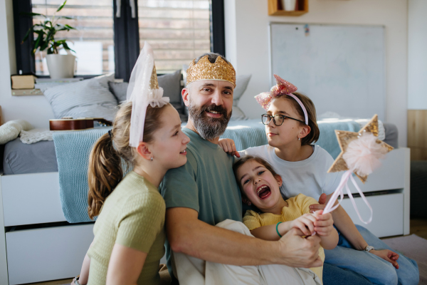 Portrait of father with three daughters at home. Girl dad concept.