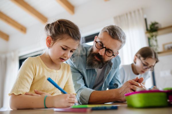 Father helping his daughters with their homework.