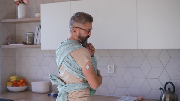 Father comforting his crying baby son, holding him in arms.