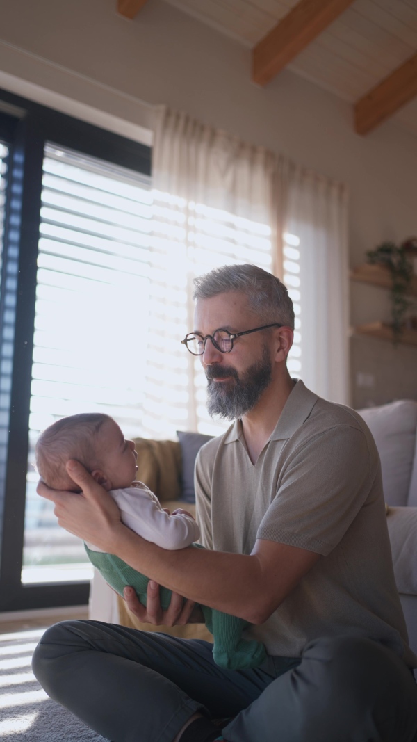 Father playing with his baby boy on a sofa.