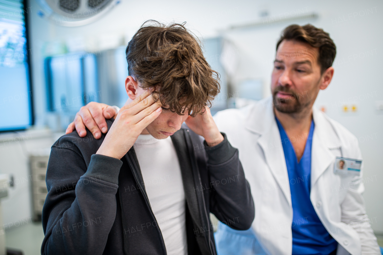 Teenager confiding in doctor about personal and health problems. Mental health evaluation for depressed teen boy.