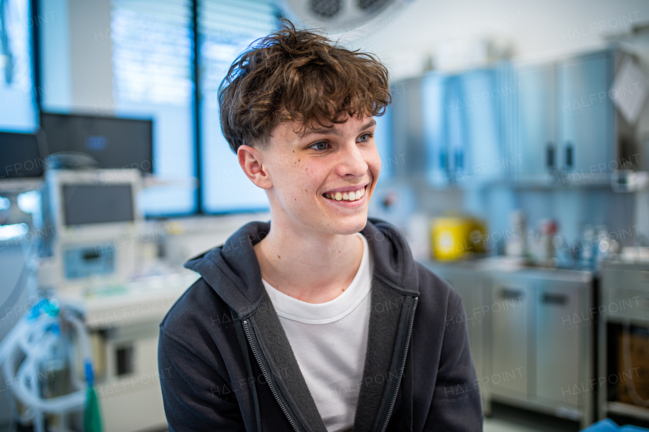 Teenage boy smiling during supportive medical consultation after receiving positive health news.