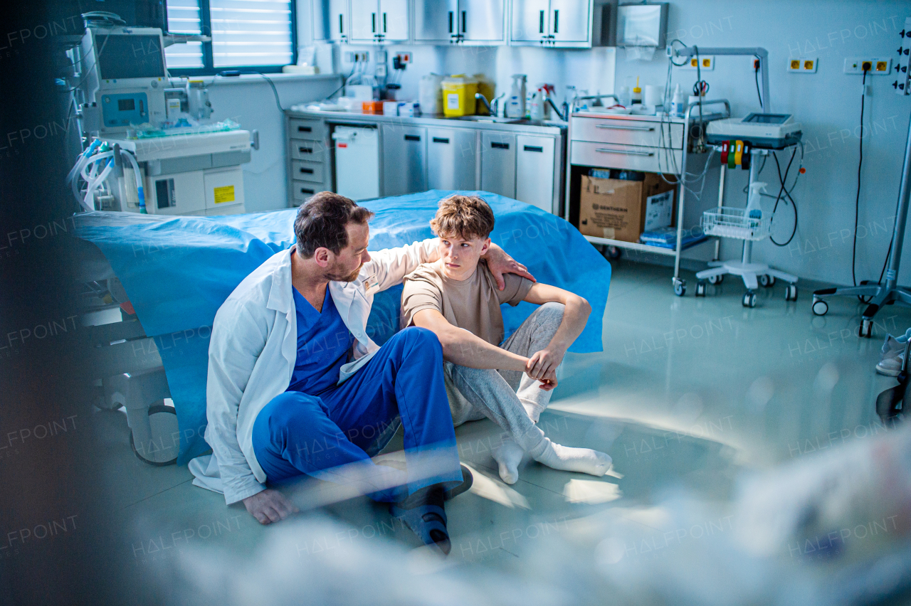 Teenager confiding in doctor about personal and health problems. Mental health evaluation for depressed teen boy.