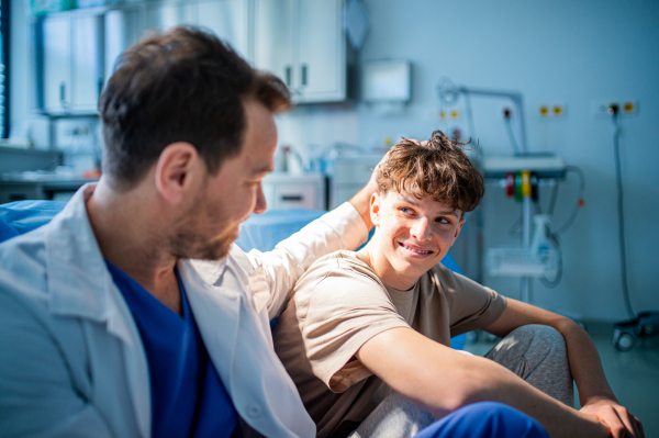 Physician supporting nervous teenage patient during mental health check, before surgery.