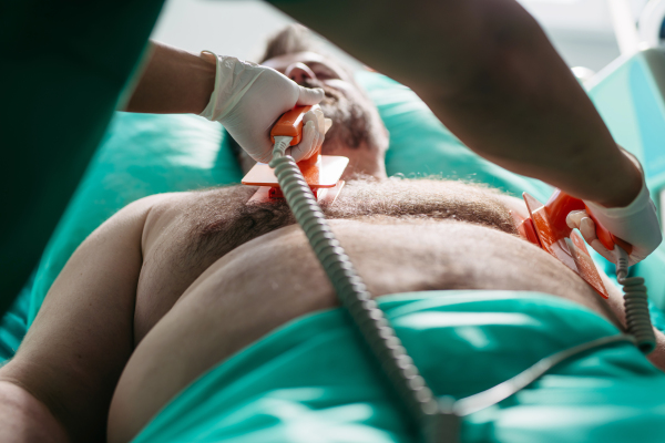 Emergency defibrillation on unconscious male patient in hospital.