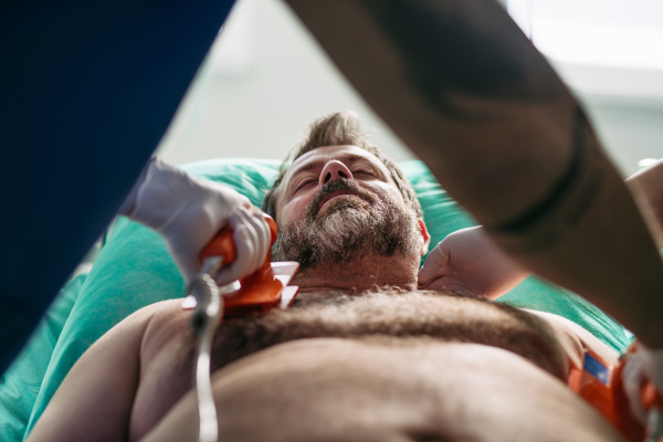 Emergency defibrillation on unconscious male patient in hospital.