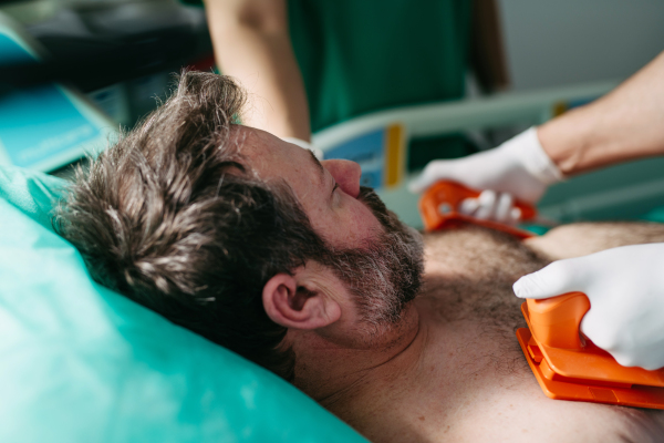 Emergency defibrillation on unconscious male patient in hospital.