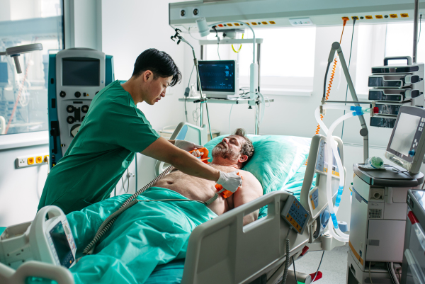 Doctor performing defibrillation and CPR during cardiac arrest.