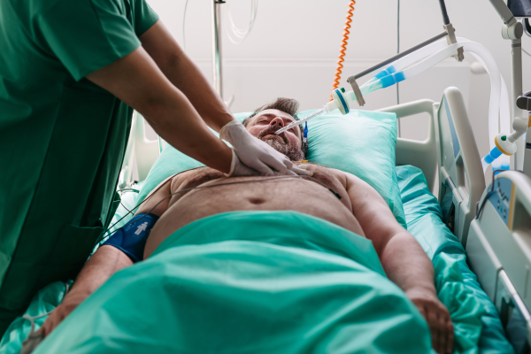 Emergency chest compressions performed on unconscious man by doctor.