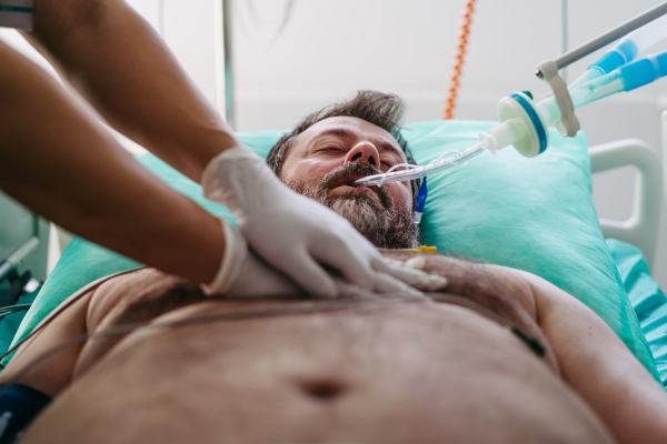 Emergency chest compressions performed on unconscious man by doctor.
