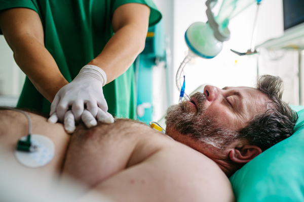 Medical team doing CPR on intubated patient in hospital.