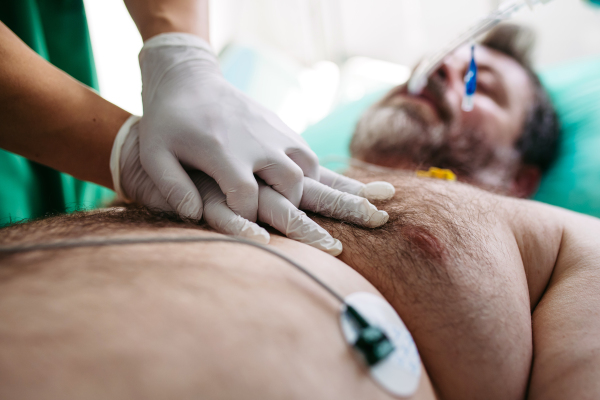 Close up of resuscitating unresponsive male patient in emergency room.