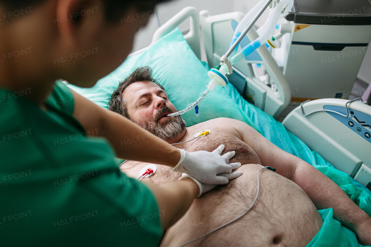 Medical team doing CPR on intubated patient in hospital.