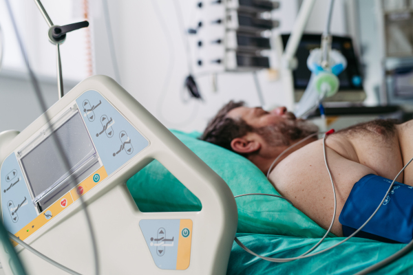 Intubated male patient lying unconscious in intensive care unit