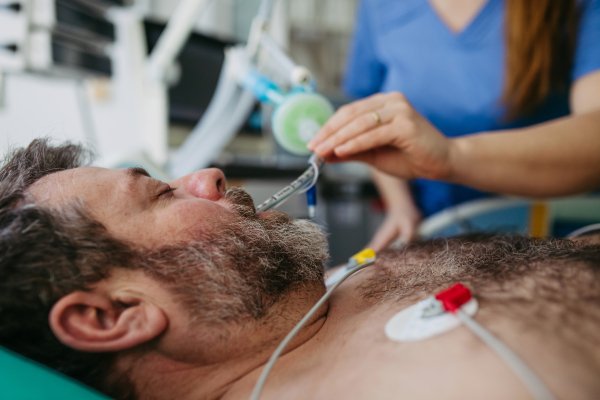 Nurse in emergency room, taking care of patient in ciritical condition.