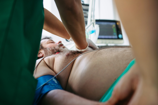Medical team doing CPR on intubated patient in hospital.