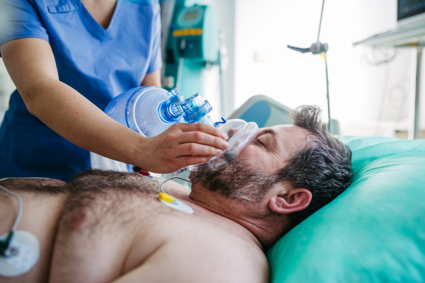 Medical team providing oxygen ventilation to unconscious patient in hospital