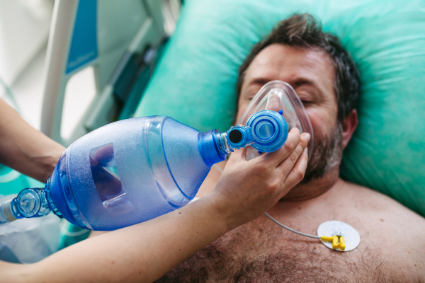 Medical team providing oxygen ventilation to unconscious patient in hospital