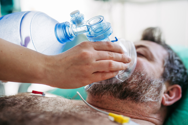 Medical team providing oxygen ventilation to unconscious patient in hospital