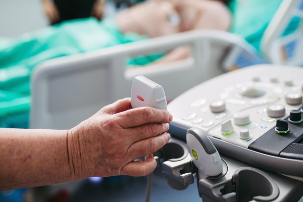Doctor's hand on ultrasond console during ultrasound procedure.