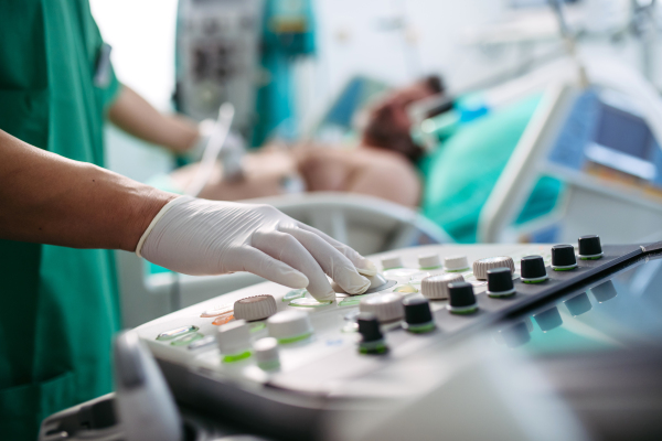 Doctor's hand on ultrasond console during abdominal ultrasound.