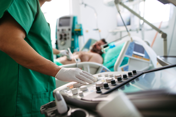 Doctor's hand on ultrasond console during abdominal ultrasound.