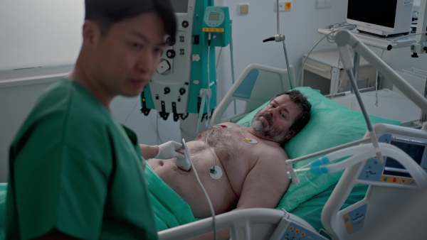 Medical professional using ultrasound probe in intensive care, abdominal ultrasound.