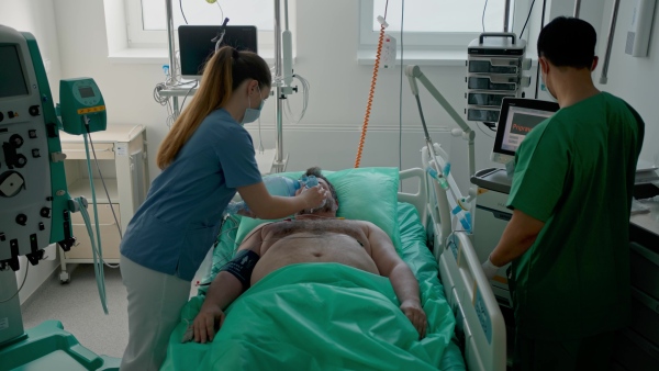 Medical team providing oxygen ventilation to unconscious patient in hospital.
