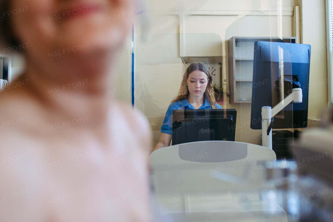 Healthcare worker performing mammography on older woman