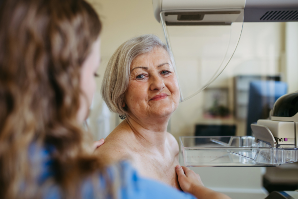 Senior female patient receiving breast cancer screening as part of routine exam