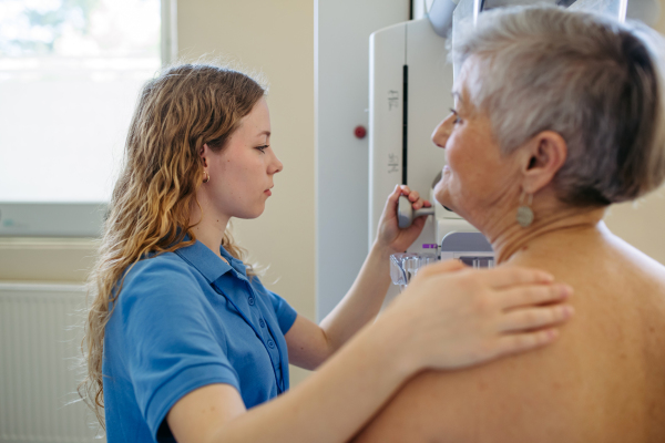 Senior female patient receiving breast cancer screening as part of routine exam