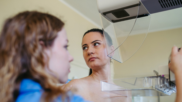Healthcare worker preparing patient for preventive breast scan
