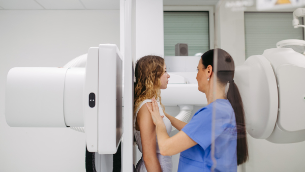 Young woman positioned on radiographic wall stand for diagnostic imaging