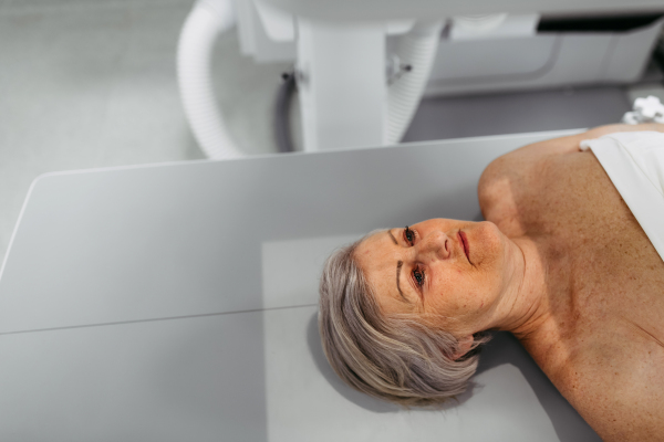 Senior patient undergoing X-ray on tilting wall unit